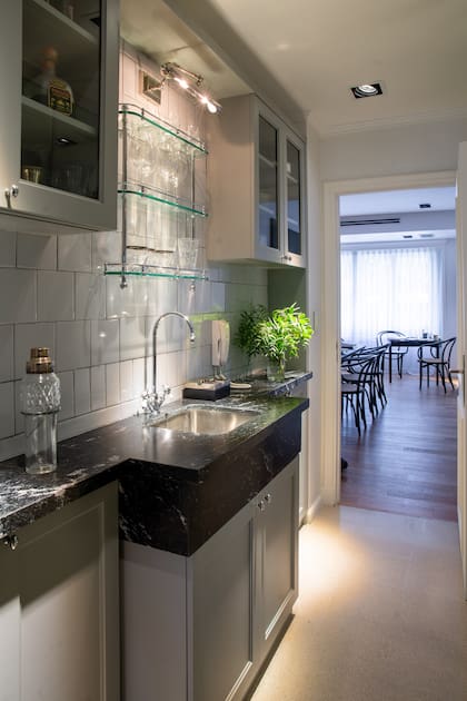 El pasillo que da de la cocina al comedor se aprovechó para armar un cancherísimo spot para guardar cristalería y todos los elementos de coctelería.