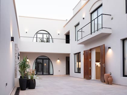 El patio central fue diseñado con arcos para las aberturas principales, colores neutros, texturas de elementos naturales y espacios despojados para transmitir serenidad.