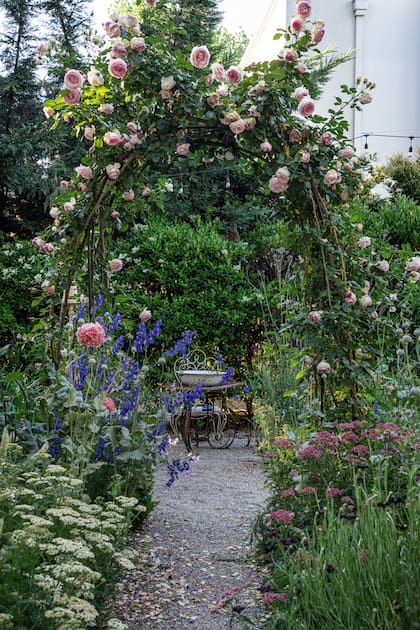 El patio interno es un laboratorio de dalias donde Carolina cultiva las variedades que más le gustan. A través del arco con un rosal ‘Pierre de Ronsard’ se accede a la huerta, que incluye flores y frutales.