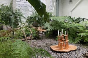 El patio interno se destaca por la frondosidad de los helechos. En el centro, candelabros de madera de incienso.