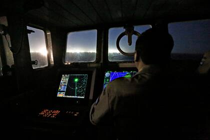 Los barcos, en su mayoría chinos, despliegan grandes brazos metálicos con potentes luces que atraen a los calamares, que son atrapados con las poteras