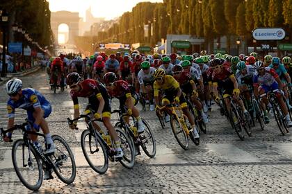 El pelotón con el lider de la carrera Tadej Pogacar, con el maillot amarillo recorren los metros finales del Tour de Francia 2020, en los Campos Eliseos con el Arco del Triunfo como marco de fondo