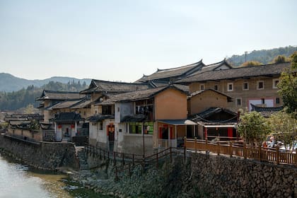 El pequeño río frente a los edificios de tierra de Fujian (también conocidos como Hakka tulou).