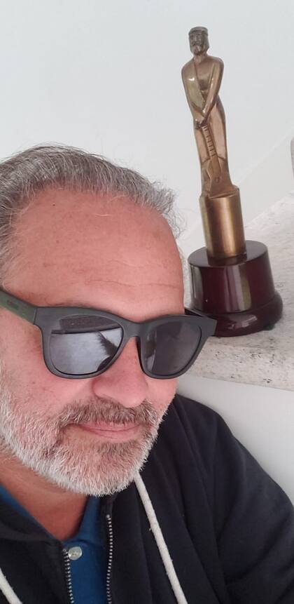 El periodista Augusto Tartufoli, autor de esta nota, junto al Martín Fierro que ganó con el programa AM en 2010. "Lo tengo en el baño así cuando las visitas vienen a casa se sacan selfies como hizo Kate Winslet con el Oscar", bromea.