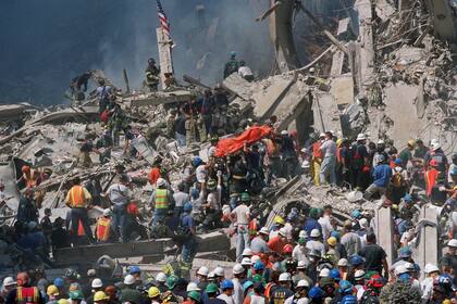 El personal de emergencia lleva una bolsa naranja para cadáveres con los restos de una víctima del accidente del World Trade Center, el jueves 13 de septiembre de 2001
