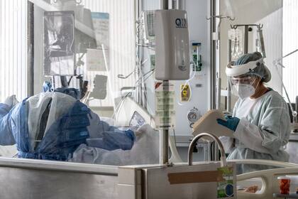 El personal de la salud que usa trajes protectores ayuda a un paciente en la unidad de cuidados intensivos en el Hospital Público El Tunal, Bogotá, el 16 de junio de 2020
