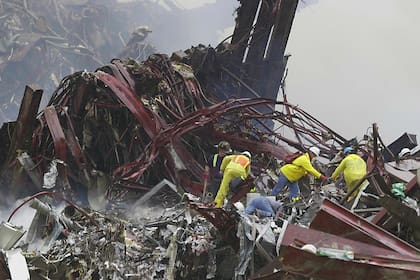 El personal de rescate trabaja junto a vigas retorcidas en la base del World Trade Center el 14 de septiembre de 2001 en Nueva York
