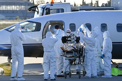 El personal médico carga a un paciente infectado con Covid-19 en un avión para una evacuación, en el aeropuerto de Nimes-Garon en Saint-Gilles, el 27 de octubre de 2020