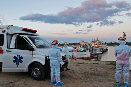 El personal médico espera a los pacientes con coronavirus traídos de las comunidades cercanas, en un puerto en el río Amazonas, en Iquitos, Perú, el 18 de junio de 2020