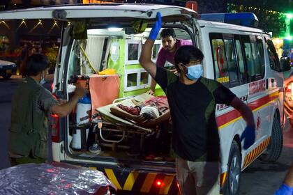 El personal médico lleva a un herido a un hospital en una ambulancia después de las poderosas explosiones fuera del aeropuerto de Kabul