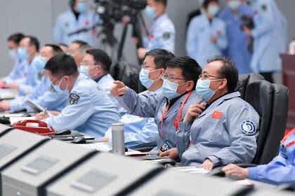 El personal técnico monitorean el proceso durante el aterrizaje de la sonda lunar Change-5 en la luna en el Centro de Control Aeroespacial de Pekín, en Pekín