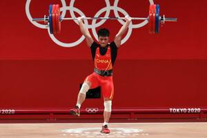 El pesista chino Li Fabin sostiene 166 kilos con una sola pierna.