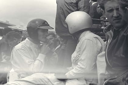 El piloto británico Ken Miles y el neocelandés Bruce McLaren intercambian opiniones en Le Mans 1966. Ambos tendrían destinos trágicos.