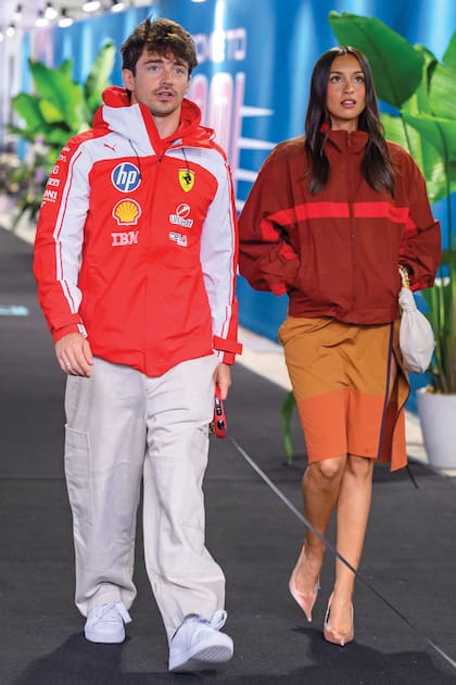 El piloto de Ferrari Charles Leclerc y su mujer, Alexandra, llegan al Team Village. La tiktoker impactó con un total look de Saint Laurent: chaqueta y falda lápiz bicolor, stilettos en punta y minicartera estilo hobo