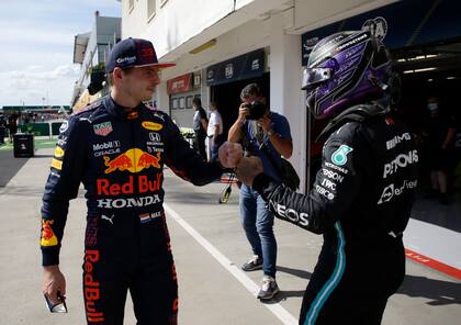 El piloto de Mercedes Lewis Hamilton de Gran Bretaña, a la derecha, después de establecer una pole position con el tercer clasificado de Red Bull Max Verstappen de Holanda después de la sesión de clasificación para el Gran Premio de Fórmula Uno de Hungría