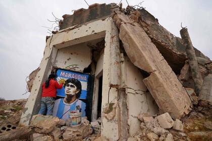 El pintor sirio Aziz Asmar dibujó en las ruinas de una casa un retrato de Diego Maradona
