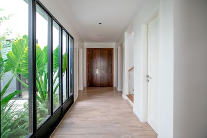 El piso es porcelanato simil madera 'Legni Habita' (ILVA) y todas las paredes y cielorasos fueron pintados de blanco. Carpinterías con marcos de PVC negro (Germán Stange).