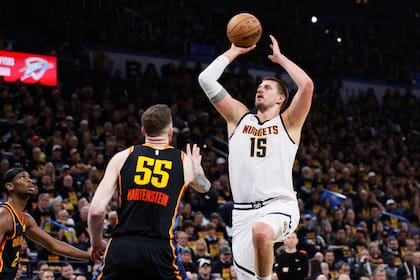 El pívot de Denver Nuggets Nikola Jokic salta para anotar frente a Isaiah Hartenstein y Shai Gilgeous-Alexander, de Oklahoma City