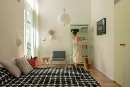 El placard (Atelier Brux) se laqueó con el 'Restoration Ivory' de Sherwin Williams. Atención al detalle del 'Cayenne' en los tiradores, a tono con la estantería '360°' de la firma italiana Magis usada como mesa de luz.