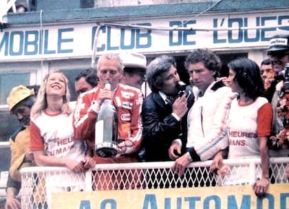 El podio de Le Mans: Paul Newman de festejo, mientras Rolf Stommelen habla con los medios