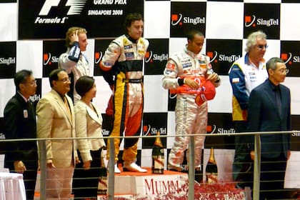 El podio de Singapur 2008: Fernando Alonso, entre Nico Rosber y Lewis Hamilton; a la izquierda del piloto británico, Flavio Briatore