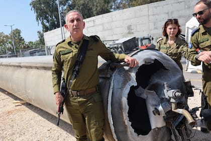 El portavoz militar israelí, el contralmirante Daniel Hagari (izq.), posa junto a un misil balístico iraní que cayó en Israel el fin de semana, durante una gira de prensa en la base militar de Julis, cerca de la ciudad de Kiryat Malachi, en el sur de Israel, el 16 de abril de 2024