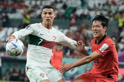 El portugués Cristiano Ronaldo (izquierda) y el surcoreano Kim Young-gwon pugnan por el balón en el partido por el Grupo H del Mundial, el viernes 2 de diciembre de 2022, en Rayán, Qatar. (AP Fto/Hassan Ammar)