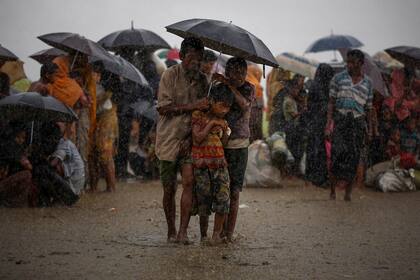 Los refugiados rohingya intentan resguardarse de las lluvias torrenciales mientras están en poder de la Guardia Fronteriza de Bangladesh (BGB) (31 de agosto de 2017)