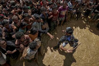 Un oficial de seguridad intenta controlar a los refugiados rohingya que esperan recibir ayuda en Coxs Bazar, Bangladesh (21 de septiembre de 2017)