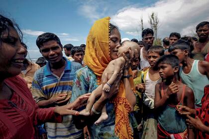 Hamida, una refugiada rohingya, llora mientras sostiene a su hijo de 40 días, que murió ahogado en la orilla en Shah Porir Dwip, Teknaf, Bangladesh
