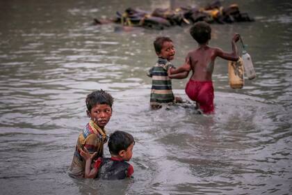 Varios niños refugiados que huyen de la violencia se abrazan mientras cruzan el río Naf a lo largo de la frontera entre Bangladesh y Myanmar (1° de noviembre de 2017)