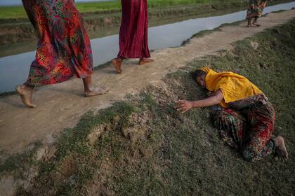 Una mujer agotada, que huye de la violencia en Myanmar, pide ayuda a otros que cruzan a Palang Khali, cerca de Coxs Bazar, Bangladesh (2 de noviembre de 2017)