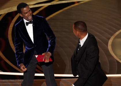El presentador Chris Rock reacciona tras ser golpeado en el escenario por Will Smith al presentar el premio a mejor documental en los Oscar