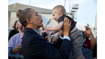 El presidente Barack Obama sostiene a un niño a su llegada al aeropuerto internacional de San Francisco, California, el 12 de febrero de 2015.