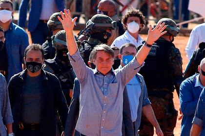 El presidente brasileño, Jair Bolsonaro (C), saluda a los partidarios durante la inauguración de un hospital de campaña en Aguas Lindas, en el estado de Goiais, Brasil, el 5 de junio de 2020, en medio de la pandemia de coronavirus Covid-19.