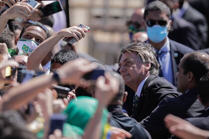 El presidente brasileño, Jair Bolsonaro, posa para una selfie con un partidario durante las celebraciones del Día de la Independencia en Brasilia, el 7 de septiembre de 2020, en medio de la pandemia del nuevo coronavirus