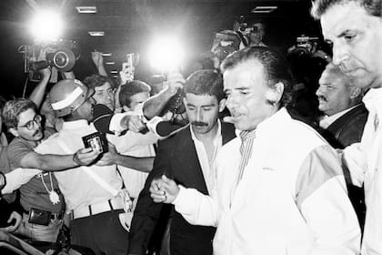 El presidente Carlos Saúl Menem llega al aeroparque tras un viaje a Santa Cruz el 29 de diciembre de 1990, tras firmar los decretos del indulto; detrás, lo acompaña su vocero, Fernando Niembro