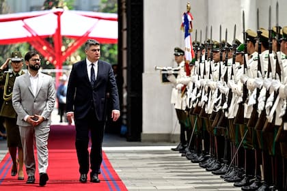 El presidente chileno Gabriel Boric y el presidente croata Zoran Milanovic llegan al palacio presidencial de La Moneda durante la visita oficial de Milanovic a Chile en Santiago, el 12 de diciembre de 2022.