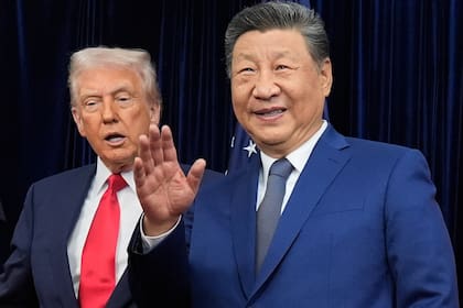 El presidente chino, Xi Jinping, saluda junto al presidente Donald Trump, antes de una reunión en el Aeropuerto Internacional de Gimhae, en Busan