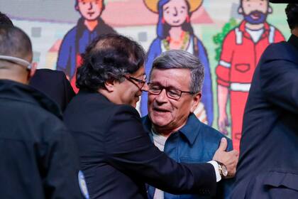 El presidente colombiano Gustavo Pedro abraza a Israel Ramírez, alias Pablo Beltrán, líder del Ejército de Liberación Nacional (ELN), durante una ceremonia para iniciar formalmente un alto el fuego de seis meses como parte de un proceso de paz en Bogotá, Colombia, el jueves 3 de agosto de 2023.