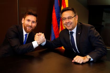 Otros tiempos: Lionel Messi estrecha la mano del presidente Josep Bartomeu. Hoy, ambos no se pueden ni ver y el jugador quiere irse de Barcelona.