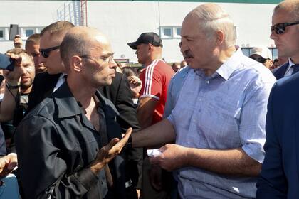 El presidente de Belarús, Alexander Lukashenko, habla con un trabajador, durante una visita a una fábrica de tractores, hoy en Minsk