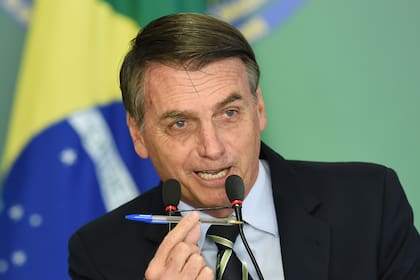 El presidente de Brasil, Jair Bolsonaro, pronuncia un discurso y muestra un bolígrafo durante la ceremonia de firma del decreto presidencial que flexibiliza la posesión de armas de fuego, en el Palacio de Planalto en Brasilia.