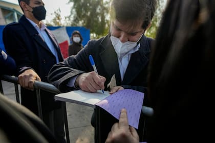 El presidente de Chile, Gabriel Boric, firma un borrador de la Constitución propuesta luego de asistir a un evento para animar a la gente a votar en el próximo plebiscito en Santiago, Chile, el jueves 21 de julio de 2022 (Foto AP/Esteban Félix)