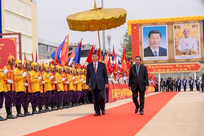 El presidente de China, Xi Jinping, pasa revista a una guardia de honor en el Palacio Real acompañado por el presidente del Senado de Camboya, Hun Sen