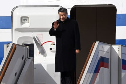 El presidente de China, Xi Jinping, saluda al desembarcar de su avión a su llegada al aeropuerto moscovita de Vnukovo el 20 de marzo de 2023.
