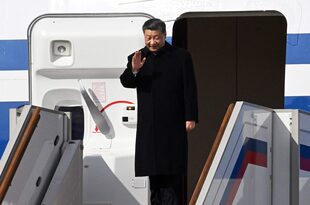 El presidente de China, Xi Jinping, saluda mientras desembarca de su avión a su llegada al aeropuerto moscovita de Vnukovo el 20 de marzo de 2023.