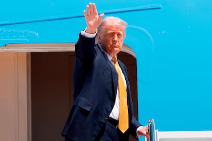 El presidente de EEUU, Donald Trump, saluda con la mano desde las escaleras del Air Force One mientras sube en la Base Conjunta Andrews, en Maryland, el martes 12 de mayo de 2026, para emprender un viaje a China con el fin de reunirse con el presidente chino Xi Jinping. (AP Foto/Luis M. Álvarez)
