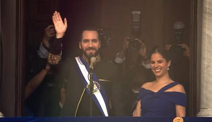 El presidente de El Salvador, Nayib Bukele, junto a su esposa, saluda desde el balcón del Palacio Nacional durante su juramentación para su segundo mandato, el 1 de junio de 2024.