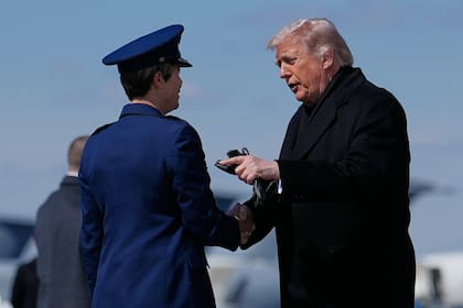 El presidente de Estados Unidos, Donald Trump, saluda a la coronela Matha "Jeannie" Sasnett, comandante de Asuntos Mortuorios de la Fuerza Aérea, al llegar en el Air Force One.